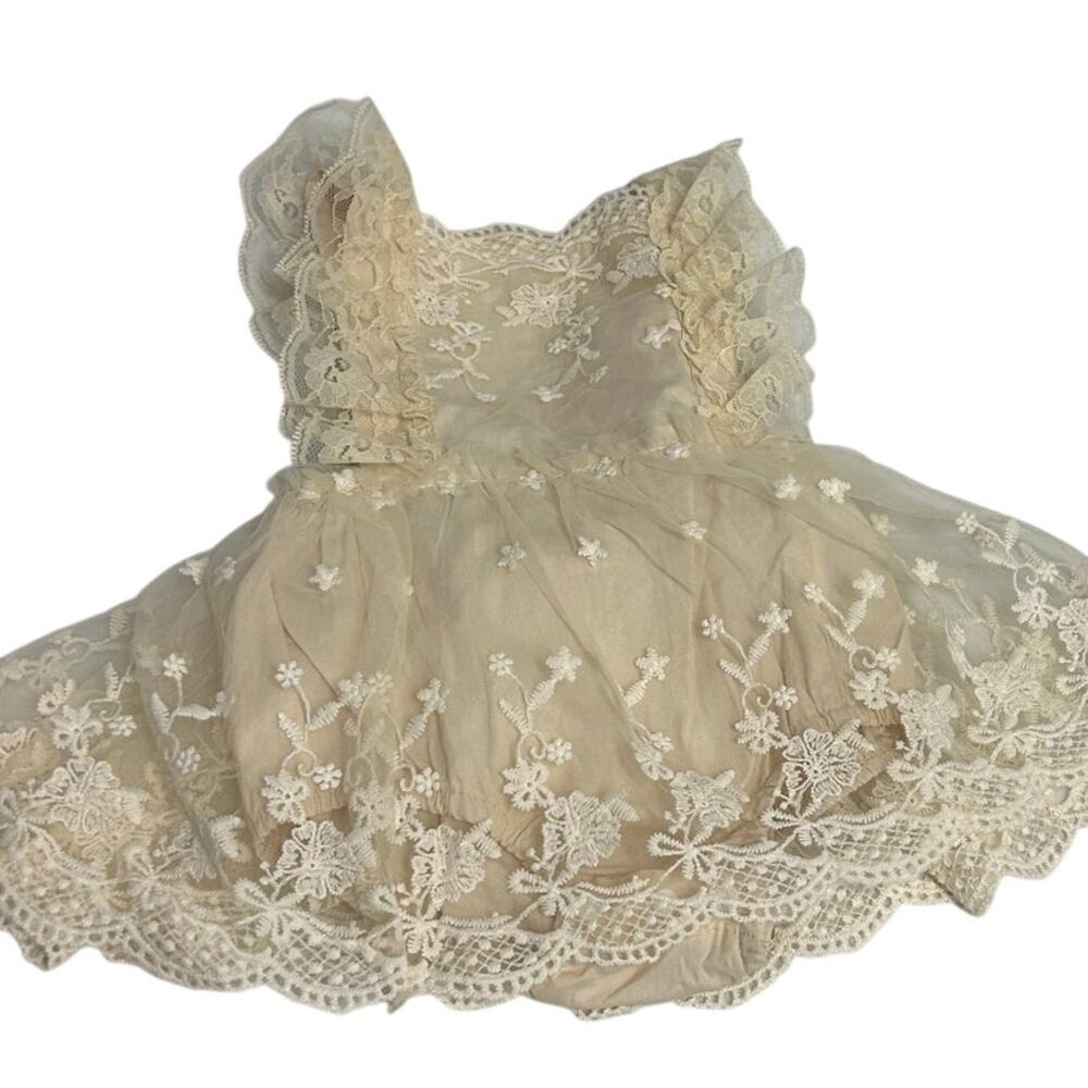 Cream-colored lace baby romper delicate floral embroidery and ruffle straps